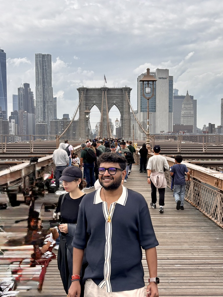 Manas Pandey on the Brooklyn Bridge with the Manhattan skyline behind him